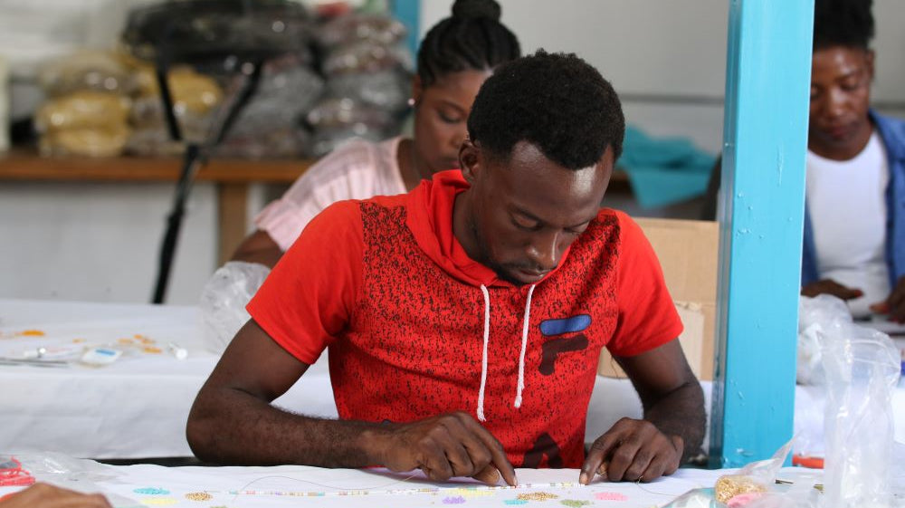 Man holding up Haitian flag in front of burning tires