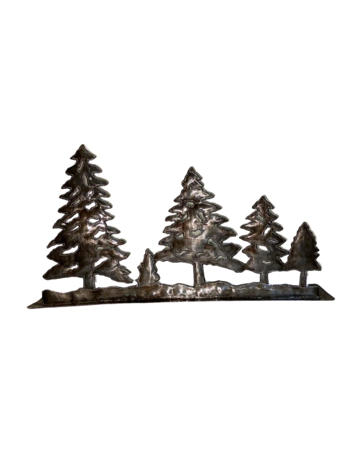 A metal art piece depicting a forest scene with several pine trees, handmade from recycled material with a rustic appearance.
