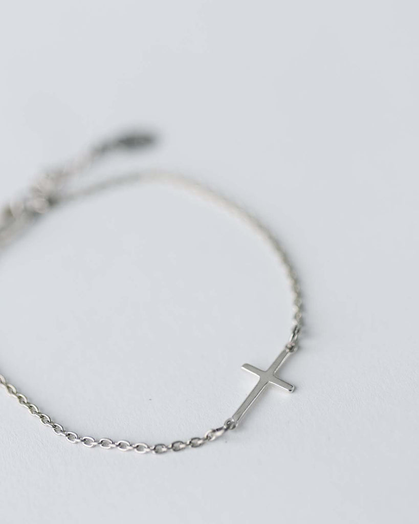 silver cross charm on silver chain bracelet