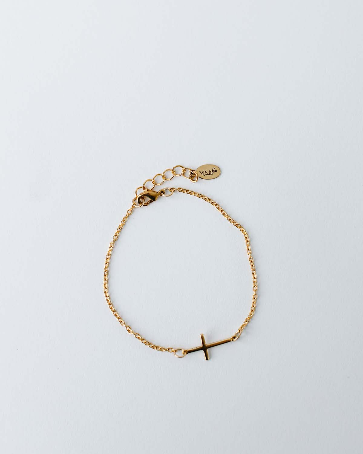 cross charm connector on a gold chain bracelet