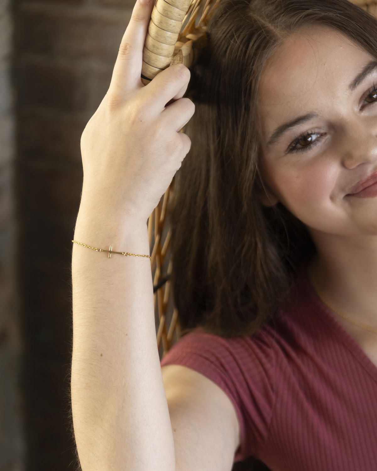 gold cross charm bracelet on model