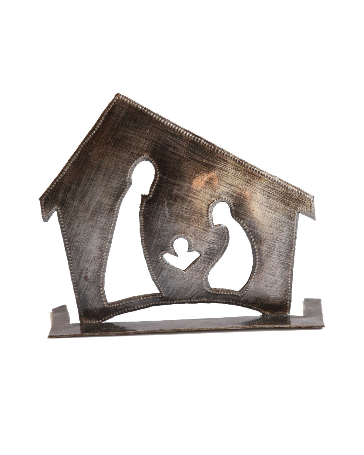 A metal nativity scene sculpture made from recycled material, featuring simplified, abstract representations of Mary, Joseph, and baby Jesus within a house silhouette.