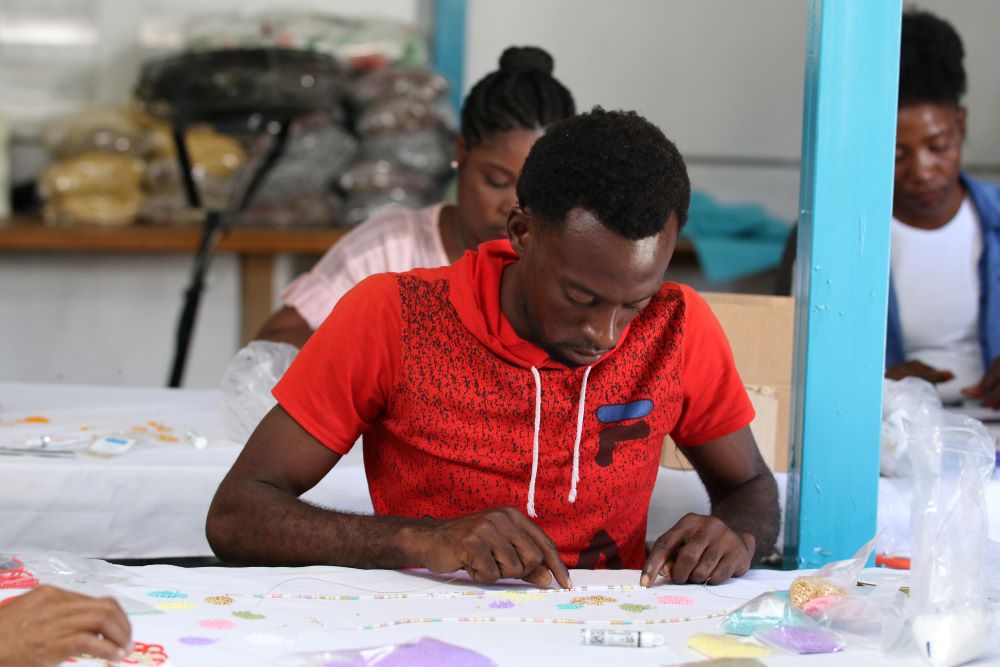 Man holding up Haitian flag in front of burning tires