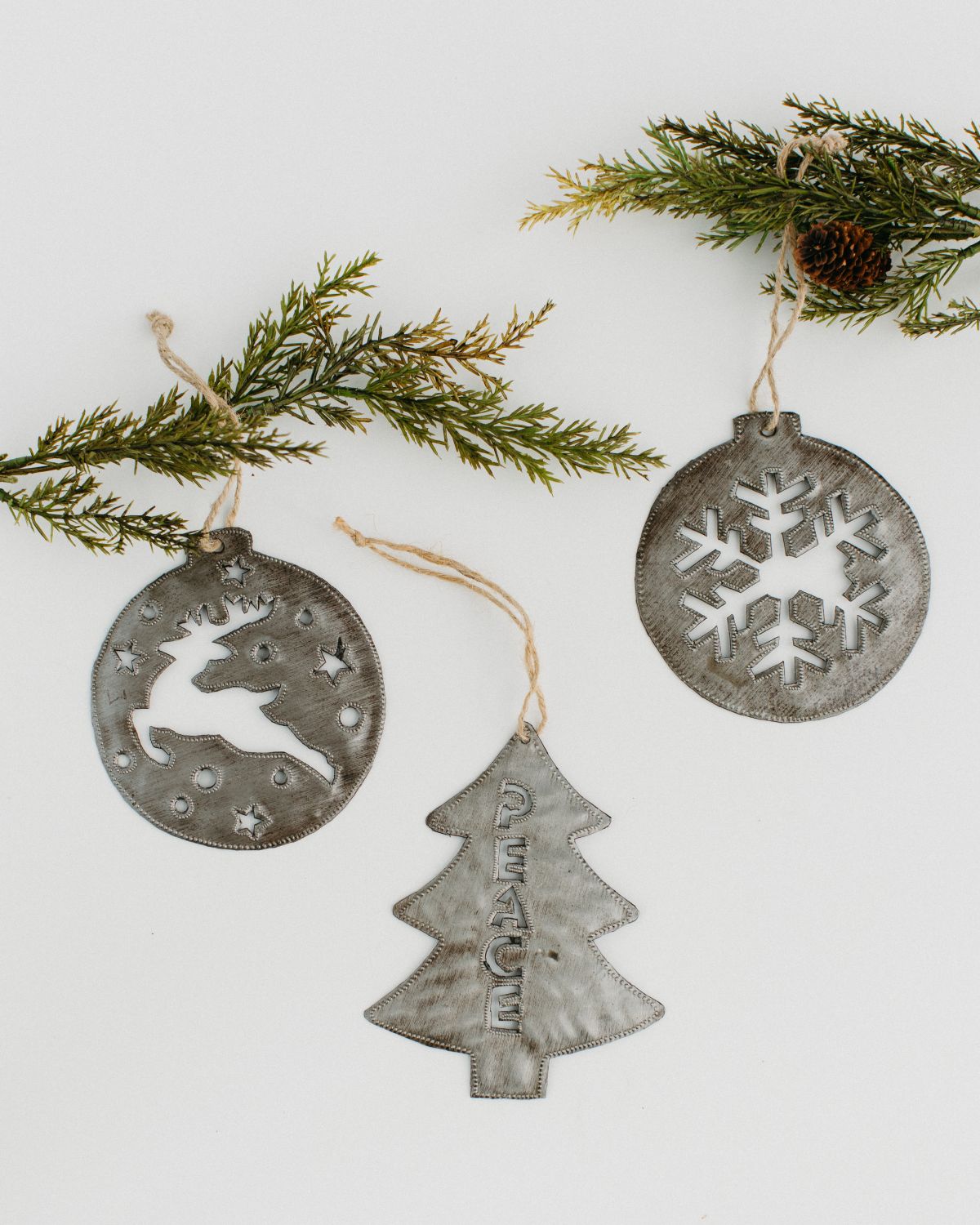 three metal ornaments  - one tree, one deer, and one snowflake