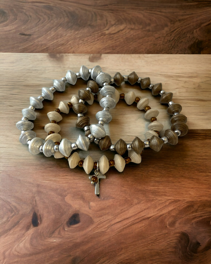3 paper bead bracelets (silver, sahara gold, and sandy beige) with a cross charm & seed beads.