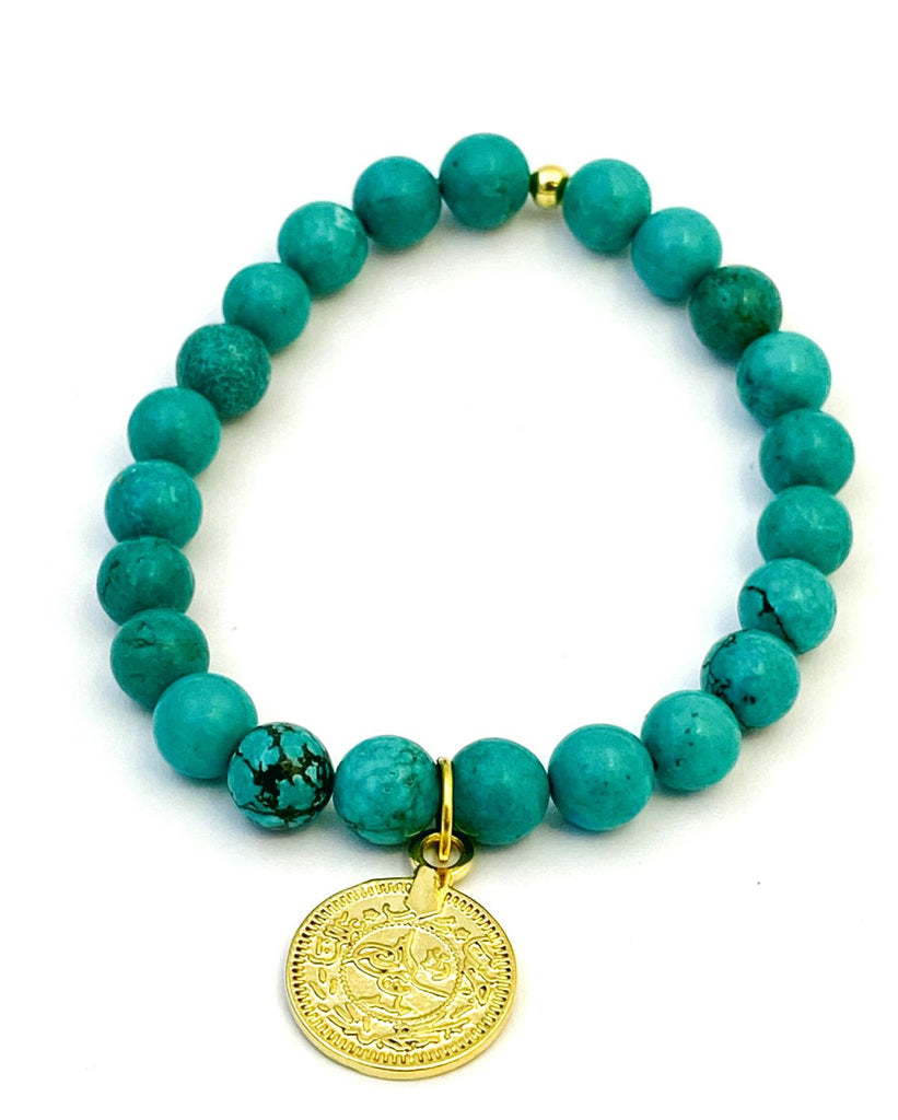 Round teal howlite beads on stretchy cord with a gold filled coin disk charm