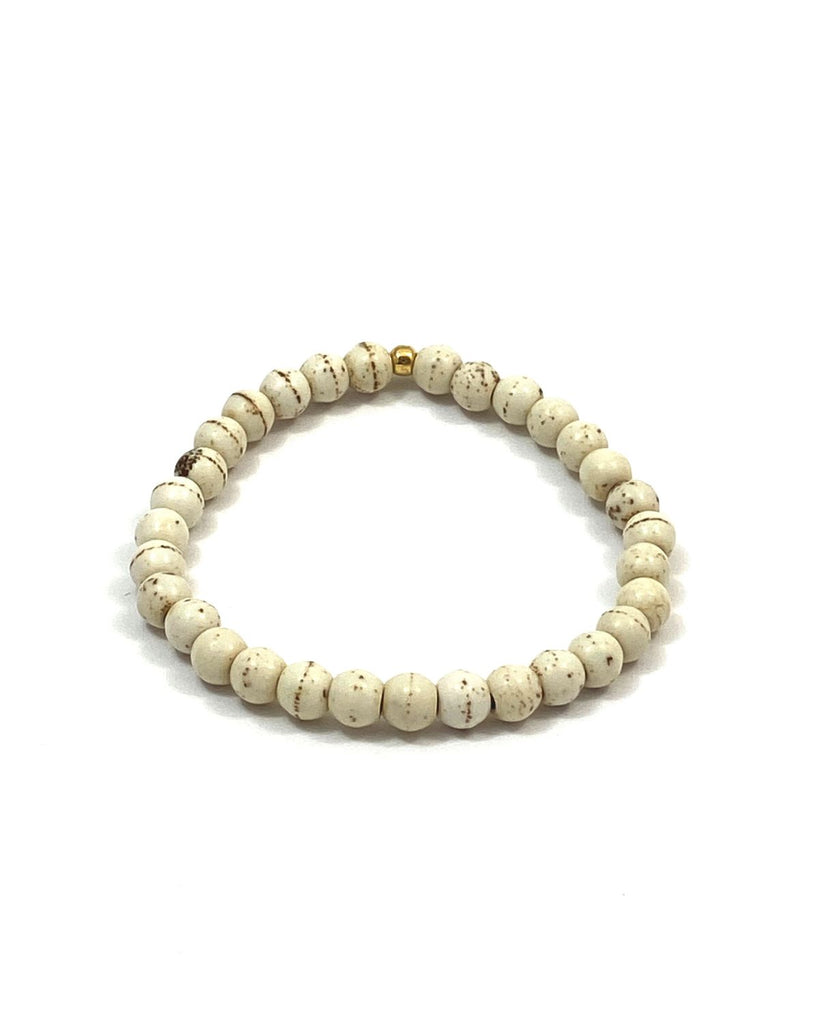 Round cream colored howlite beads with brown markings on a stretchy cord