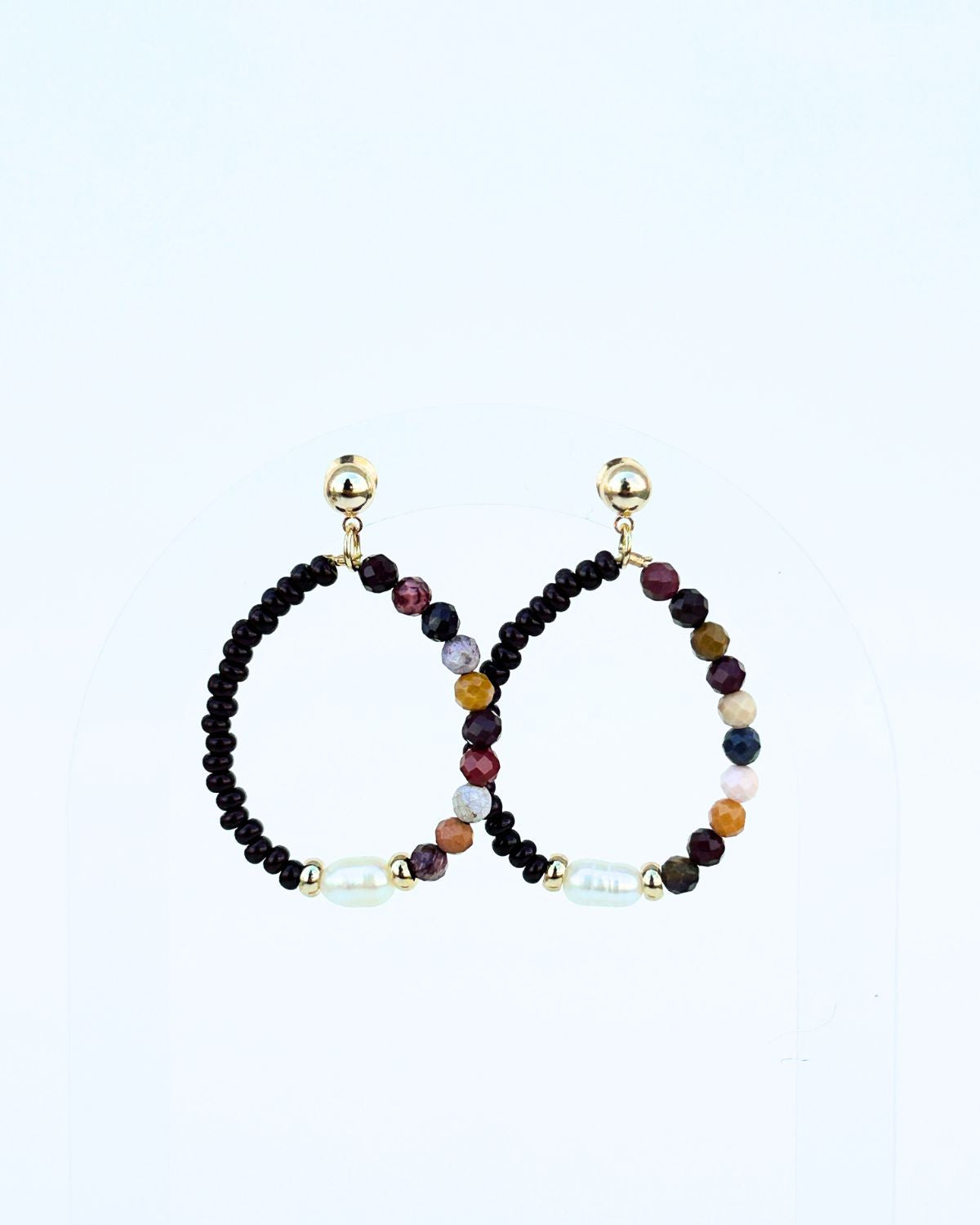 Pair of beaded earrings with gold accents on a light gray background