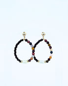 Pair of beaded earrings with gold accents on a light gray background