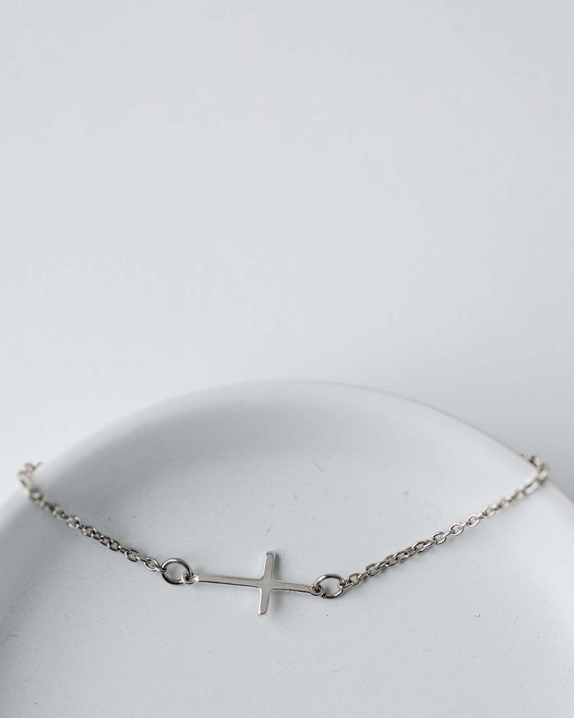 silver cross charm on silver chain bracelet