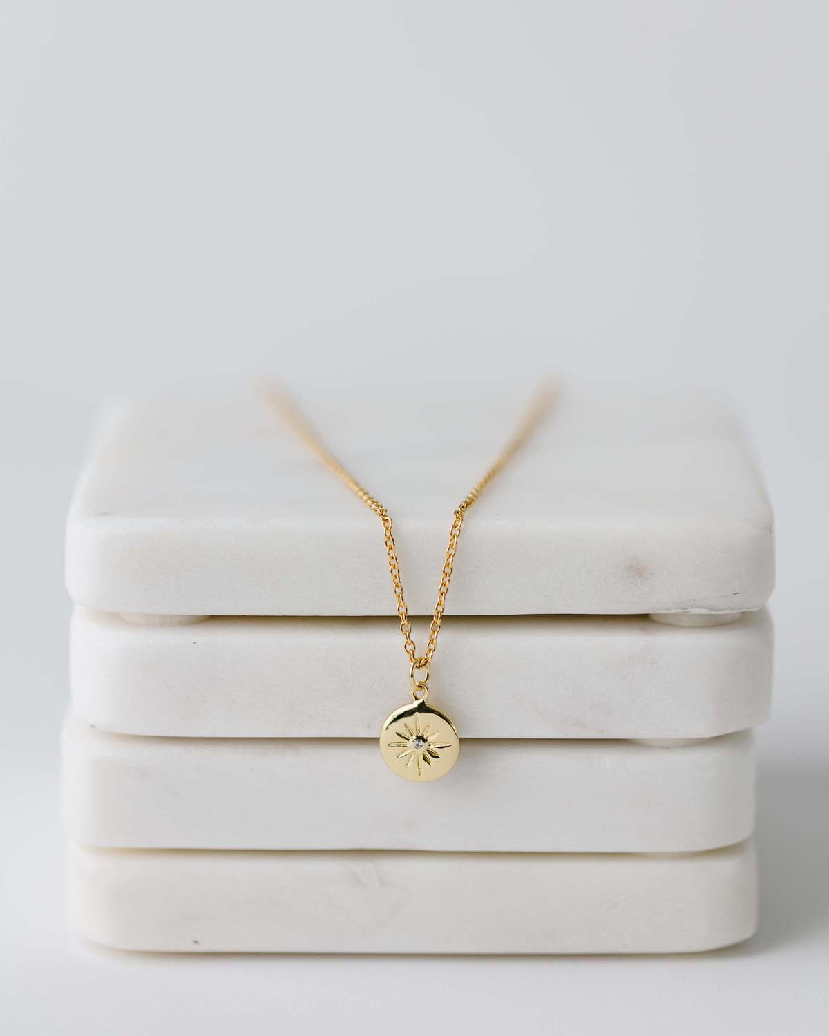 short gold chain with small starburst charm