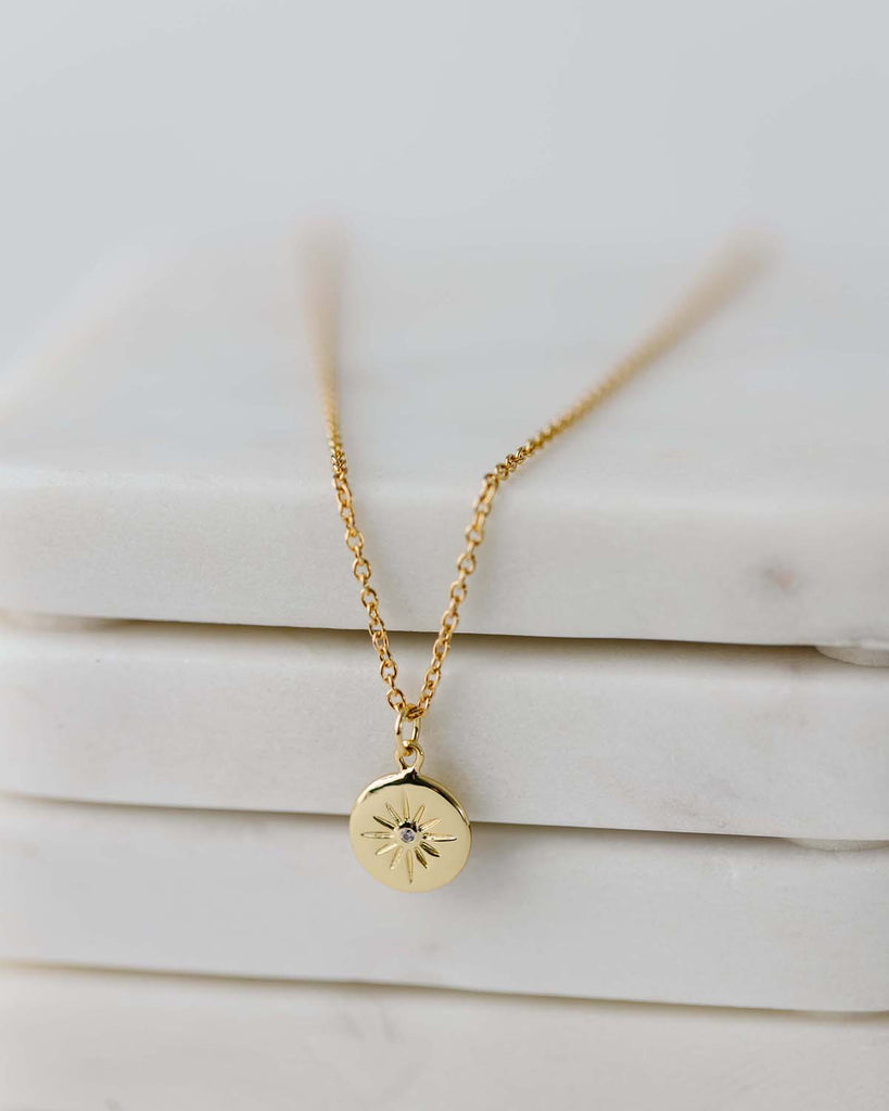short gold chain with small starburst charm