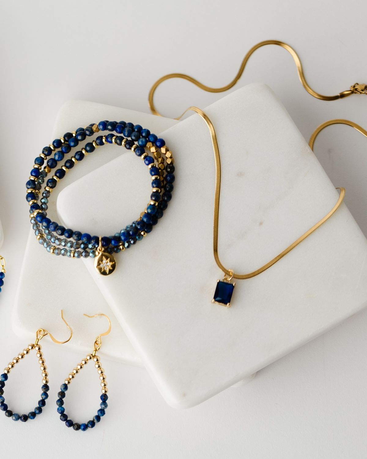 Dark blue cubic zirconia rectangular pendant in 24k gold setting on a 17.5" gold plated herringbone chain