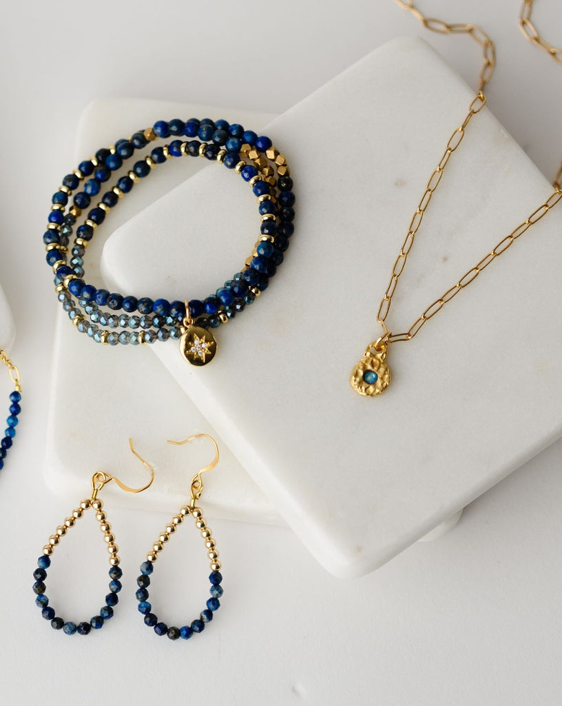 2" teardrop shaped earrings strung with gold filled and lapis lazuli beads and a 20" stretch cord with blue and gold beads