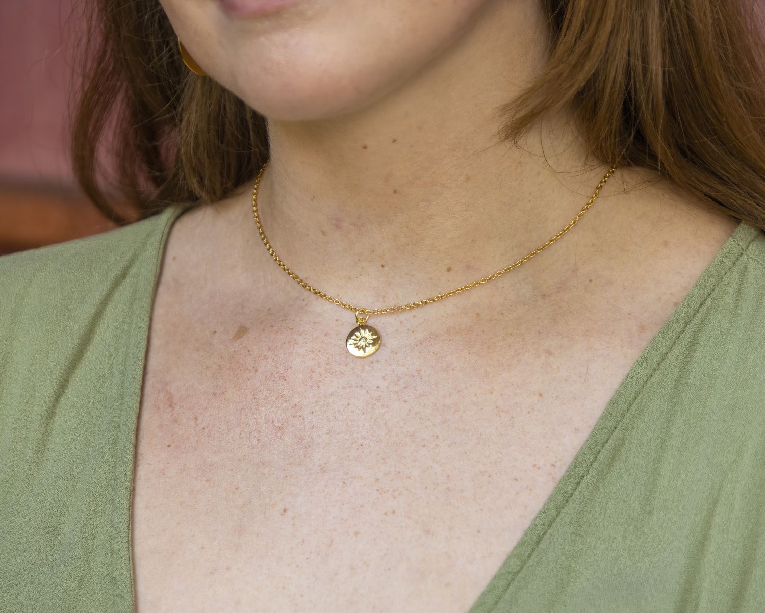 short gold chain with small starburst pendant