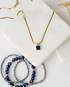Dark blue cubic zirconia rectangular pendant in 24k gold setting on a 17.5" gold plated herringbone chain