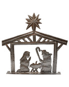 A metal nativity art piece with a star-shaped top, depicting the stable scene with the baby Jesus and the shepherds.